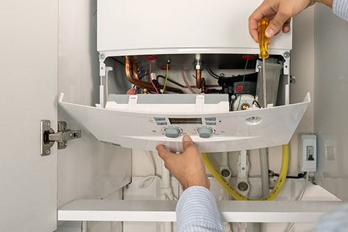 Heating technician repairing a residential boiler in Rocklin