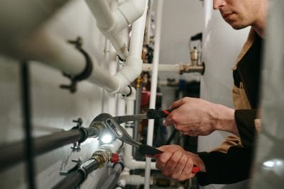 Technician inspecting commercial plumbing pipes in Rocklin
